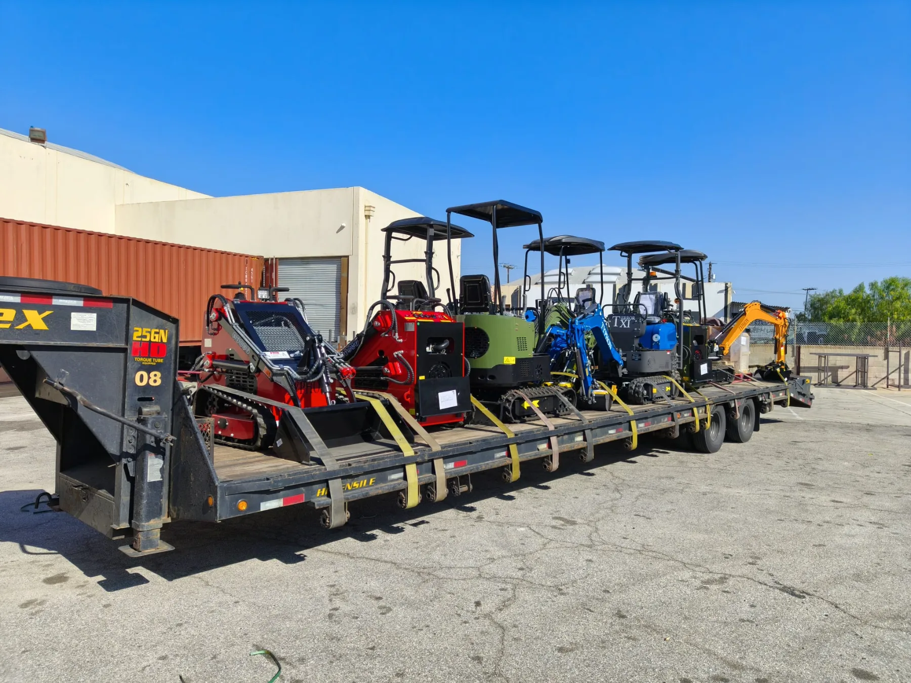 Equipment lined up in warehouse yard during sunny morning staging