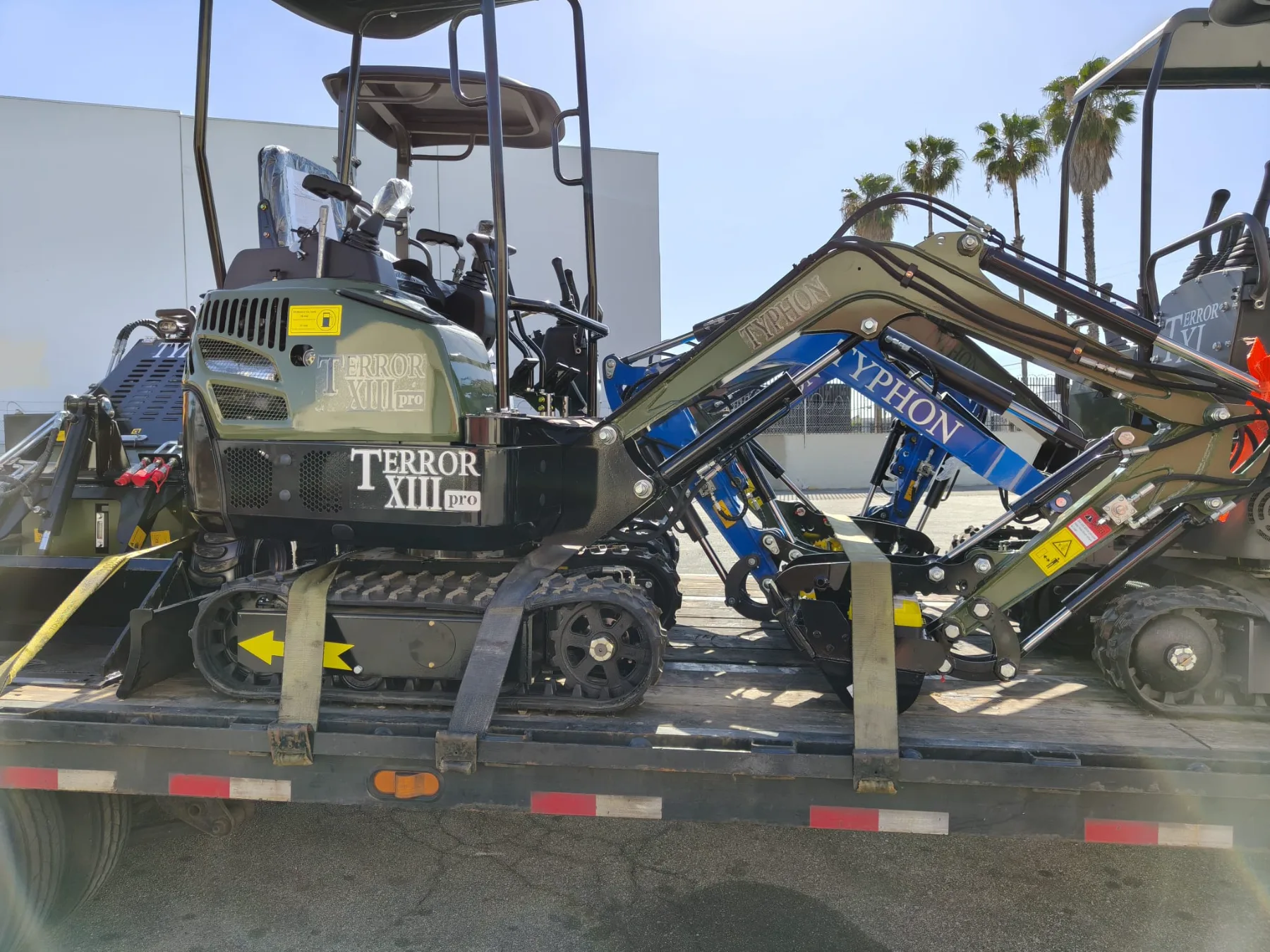 Tracked compact dumpers staged in warehouse aisle