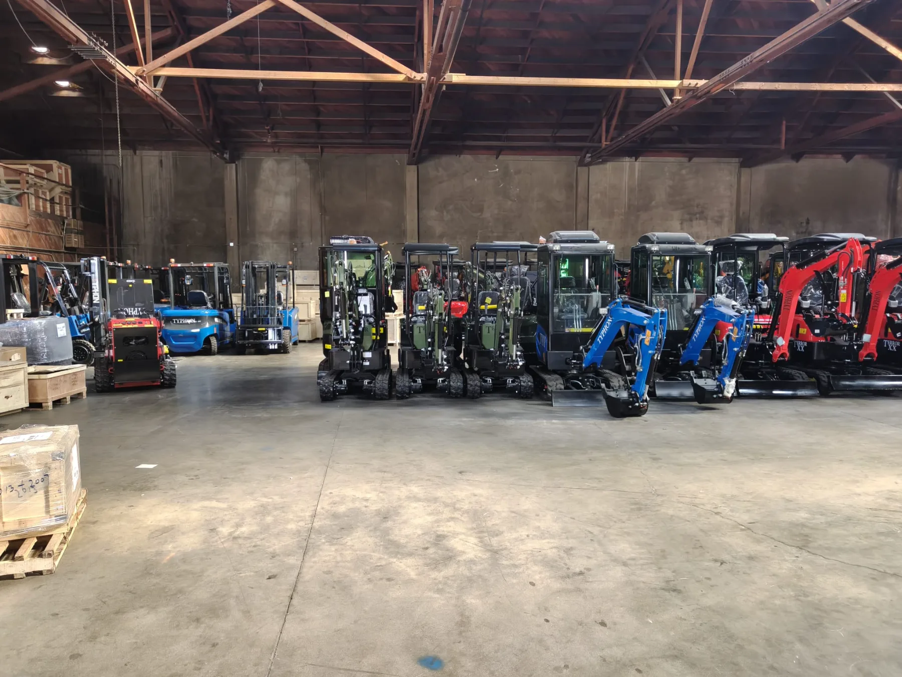 Row of brand new blue warehouse forklifts with safety lights