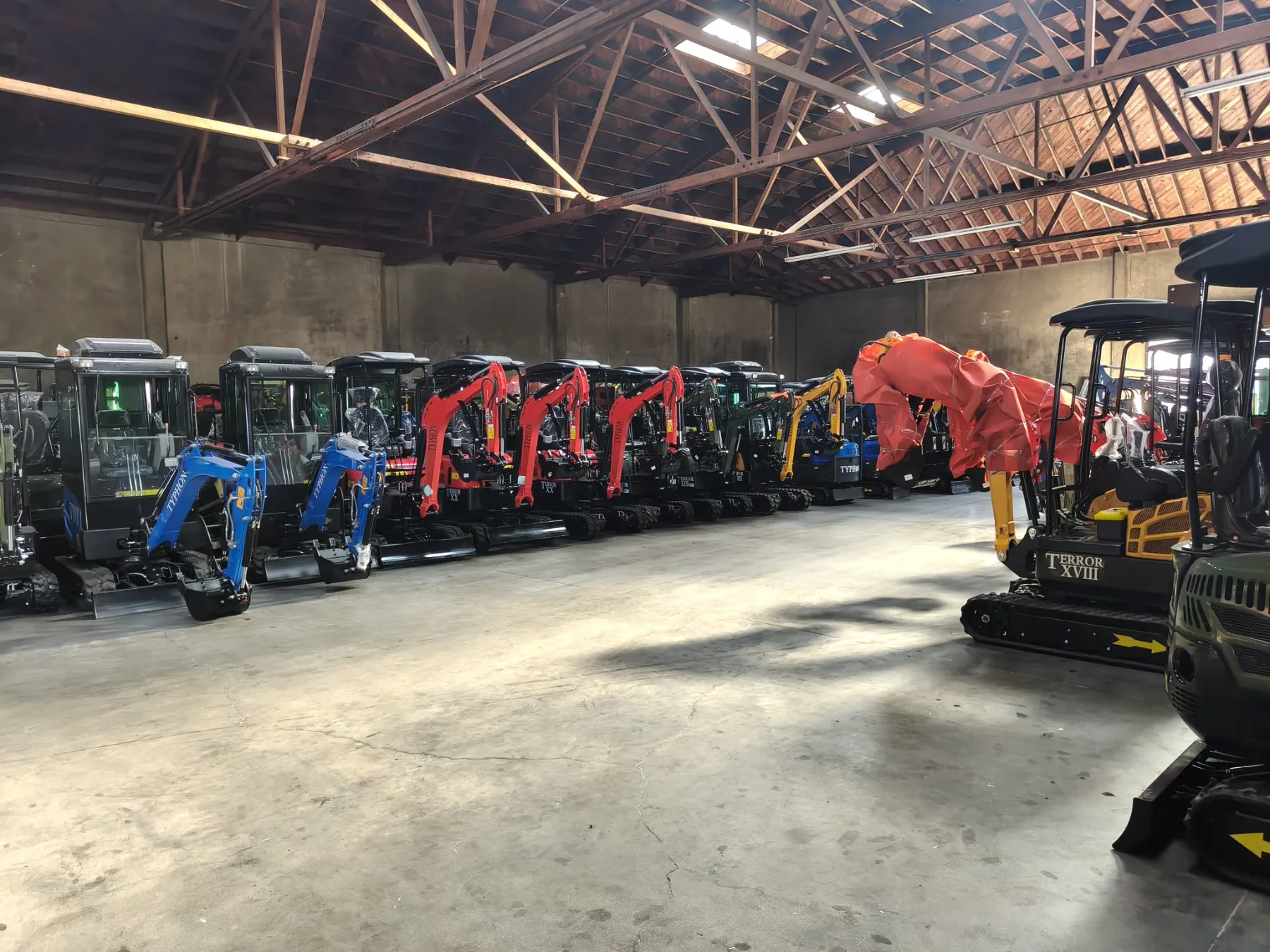 Equipped mini excavator resting on asphalt testing area