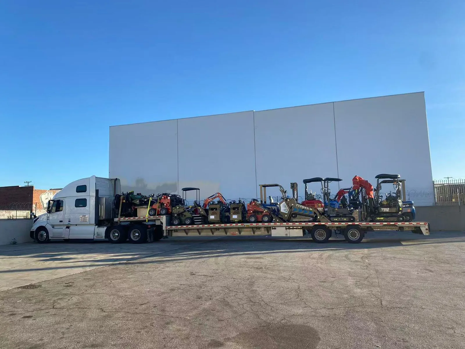 Compact machines parked on asphalt worksite testing pad